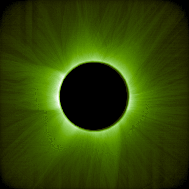 Esta es una imagen del Sol durante un eclipse solar artificial. Sobre un fondo negro, el cuerpo brillante del Sol está cubierto por un disco negro, del cual se extienden zarcillos verdes claros, similares a pelos, en todas direcciones. Una luz verde más brillante se asoma por detrás del borde del disco negro, desvaneciéndose lentamente hacia los bordes exteriores de la imagen.